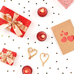 Creative Valentine's Day greeting card with red decorations and gift boxes, golden heart confetti on white background, copy space, top view