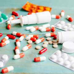 Tablets and capsules are scattered on the table.