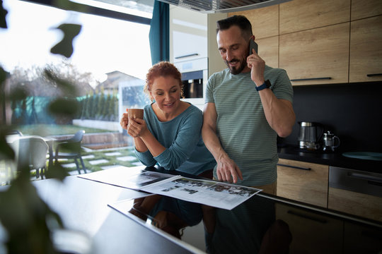 Happy couple making call in kitchen stock photo
