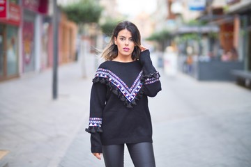 Young beautiful girl wearing sweater walking at street town