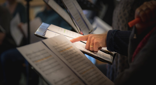 Hand zeigt auf Noten bei Chorprobe, geringe sch&auml;rfentiefe