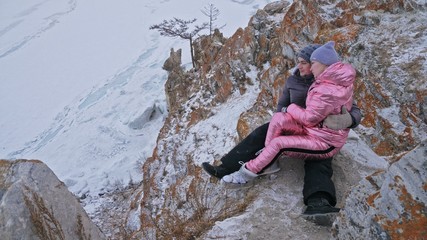 Obraz premium Couple enjoying walking outdoors in winter top mountains. Active couple walking on through snow together winter time beautiful winter sunny day. Couple of hiker walk on trail among snow covered hill.