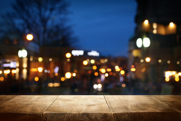 background Image of wooden table in front of street abstract blurred lights view