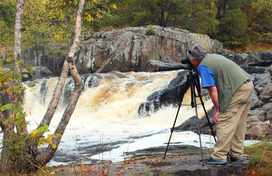 Nature Photographer taking a photo of a Waterfall
