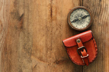 top view of compass over woodentable background. explorer and adventure concept