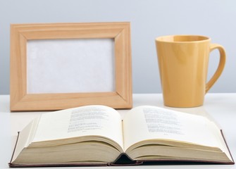 Close-up of book, cup and picture frame.