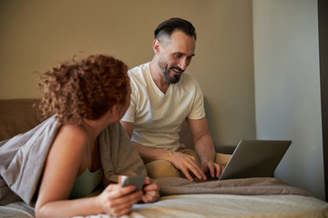 Adult lovely couple spending time in their bedroom at home