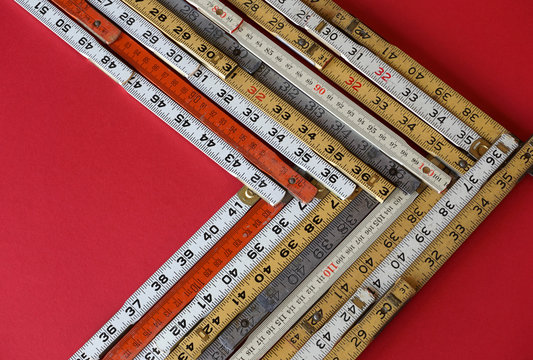 Folding rulers in metric and inches on red background form a vector chart or graph representing accuracy, measurement, increase, growth and results with copy space.