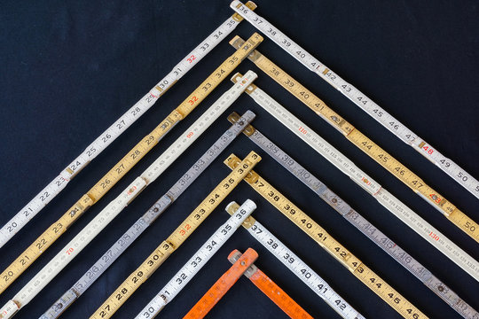 Vectors of wood and steel folding rulers in metric and inches on black background. Concepts of business chart representing accuracy, measurement, increase, growth and results with copy space.