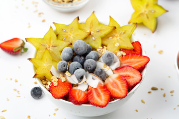 Healthy breakfast with granola, carambola, blueberry, strawberry and coconut chips. 