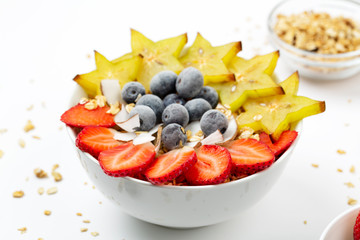 Healthy breakfast with granola, carambola, blueberry, strawberry and coconut chips. 