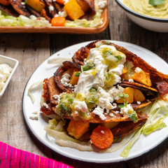 Mexican red enchiladas with potato and pork chorizo also called Potosinas on wooden background