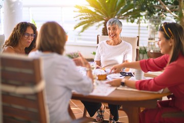 Young beautiful girl smiling happy and confident sitting dinking cup of coffee at terrace
