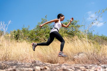 Young Black Woman Running and  Jumping at Forest Trail.