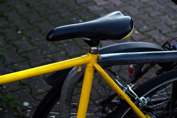Rennrad in leuchtendem Gelb mit schwarzem Sattel auf dunklem Verbundpflaster auf an der Hanauer...