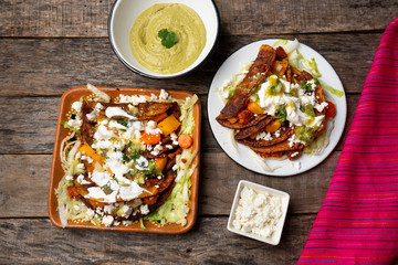 Mexican red enchiladas with potato and pork chorizo also called Potosinas on wooden background