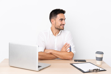 Young business man with a mobile phone in a workplace laughing