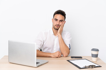 Young business man with a mobile phone in a workplace unhappy and frustrated