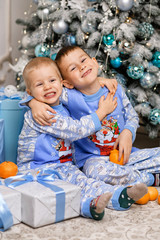 Fototapeta premium Little boys celebrate new year. Santa's expectation. Two loving brothers