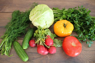 Tomatoes cucumbers cabbage radish dill and parsley on a table in the village
