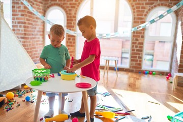 Adorable toddlers playing around lots of toys at kindergarten