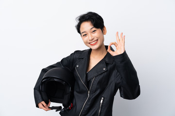 Young Asian girl with a motorcycle helmet over isolated white background showing ok sign with fingers