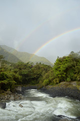 a double rainbow shot at a summer day in Baños, Ecuador