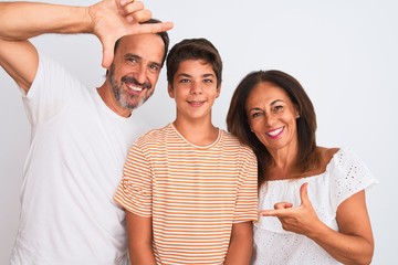 Family of three, mother, father and son standing over white isolated background smiling making frame with hands and fingers with happy face. Creativity and photography concept.
