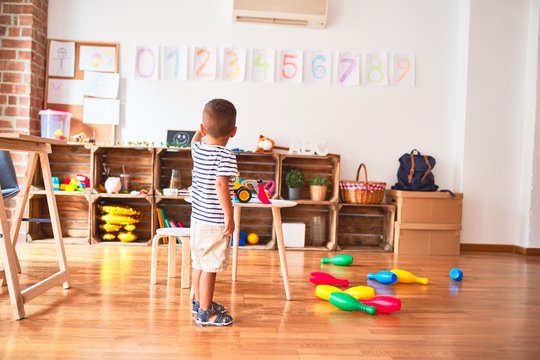 Beautiful toddler boy playing bowling at kindergarten