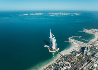 Aerial view from a plane of Dubai Jumeirah district cityscape and world islands on a sunny day. Dubai, United Arab Emirates.