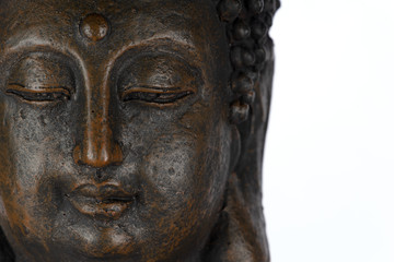 Fototapeta na wymiar Gesicht einer bronzefarben Buddha-Skulptur isoliert auf weißem Hintergrund mit Platz für Text