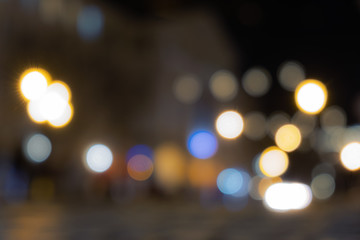 A crowd of people moving on the old european city night street defocused blurred abstract image