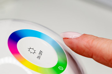 Woman finger turning off the light. Pressing index finger on lighting switch. Energy saving concept.