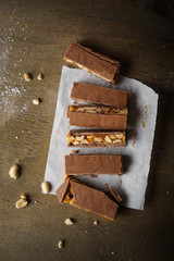 Homemade snickers bars. Peanuts in caramel covered with milk chocolate. Top view