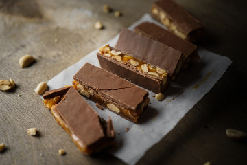 Homemade snickers bars. Peanuts in caramel covered with milk chocolate. side view