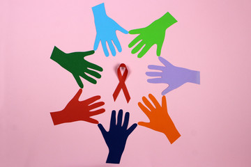 A circle of colored paper hands. AID, HIV red ribbon. Symbol of awareness, charity, support in disease, illness, ill. Medical health care, help and hope.