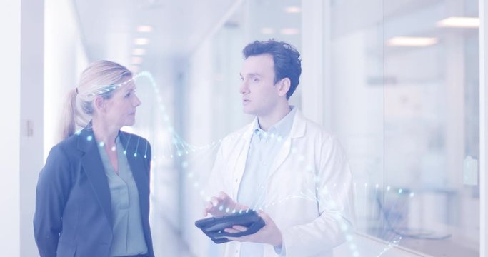 Medic and consultant in a meeting walking through hospital