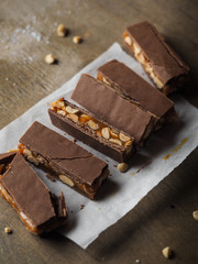 Homemade snickers bars. Peanuts in caramel covered with milk chocolate. 