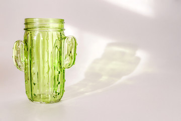 Green glass stands on a white background.