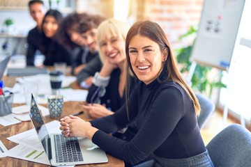 Group of business workers sitting in line with smile on face. Looking at the camera, young beautiful woman smiling at the office