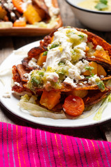 Mexican red enchiladas with potato and pork chorizo also called Potosinas on wooden background