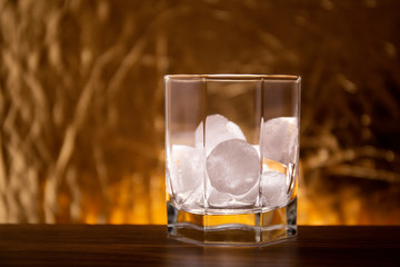 glass of whiskey and ice on wooden table