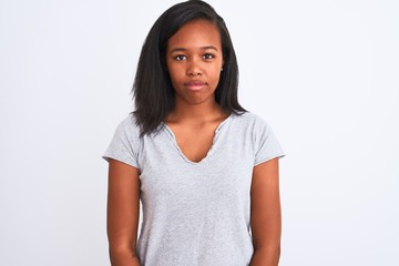 Beautiful young african american woman wearing casual t-shirt over isolated background with serious expression on face. Simple and natural looking at the camera.