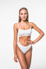 Muscular woman's body in white lingerie isolated on white background