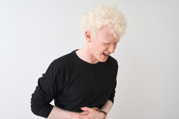 Young albino blond man wearing black t-shirt standing over isolated white background with hand on stomach because indigestion, painful illness feeling unwell. Ache concept.