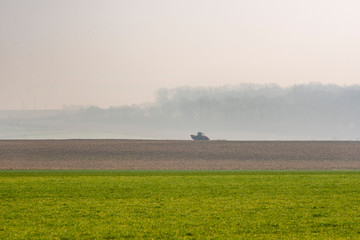 Obraz na płótnie Canvas France. Picardie. Somme. Un tracteur au milieu de terres agricoles cultivées. A tractor in the middle of cultivated agricultural land.