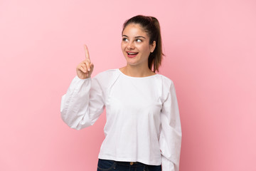 Young brunette girl over isolated pink background intending to realizes the solution while lifting a finger up