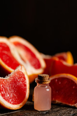 Concept of natural fruity organic ingredients in cosmetology. Extract of citrus for moisturizing, delicate skin nutrition, pore narrowing and anti-cellulite effect. Wooden background, copy space