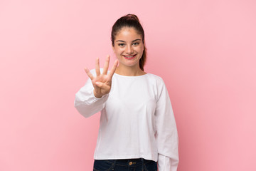 Young brunette girl over isolated pink background happy and counting four with fingers