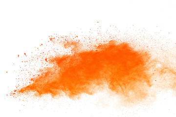 Abstract orange powder explosion. Closeup of orange dust particle splash isolated on white background.
